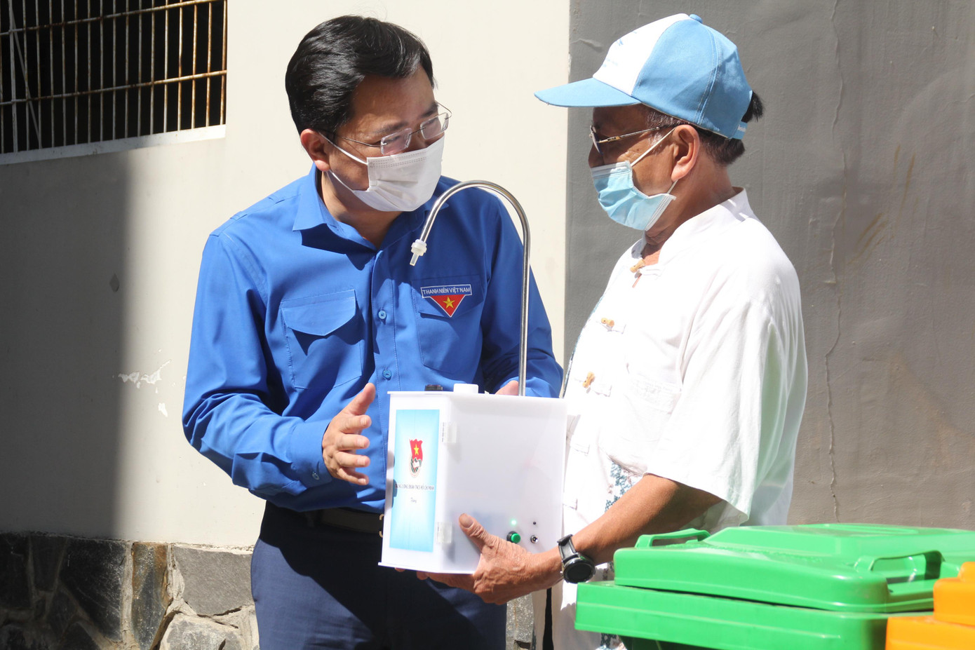 Anh Nguyễn Anh Tuấn trao máy sát khuẩn cho đại diện Ban quản trị chung cư C7-C8