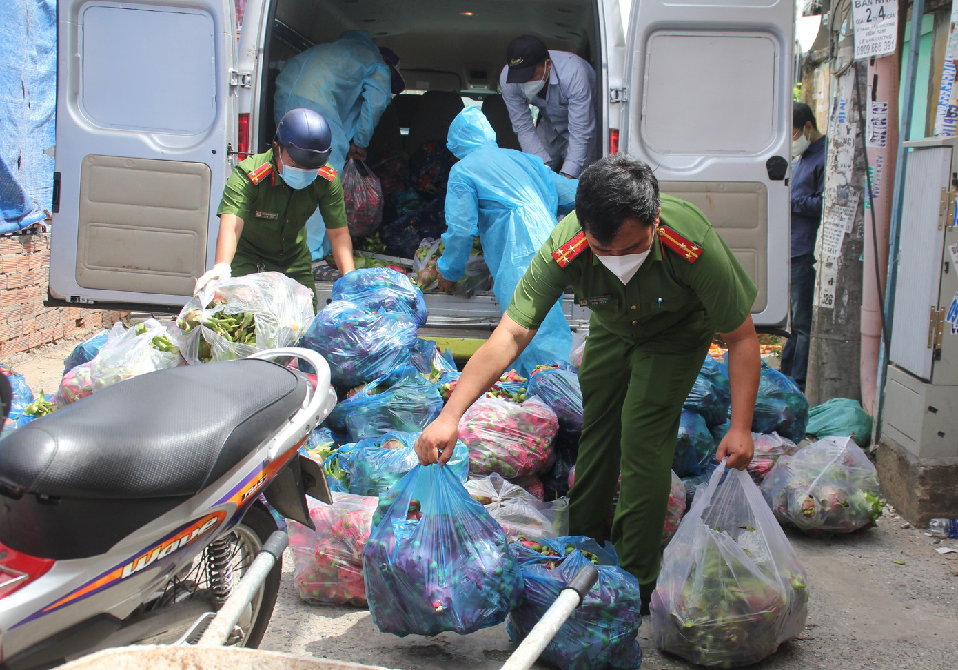 Lực lượng chức năng cùng bà con chuyển quà của Mạnh thường quân vào bên trong hẻm phong tỏa. Lực lượng chức năng cùng bà con chuyển quà của Mạnh thường quân vào bên trong hẻm phong tỏa.