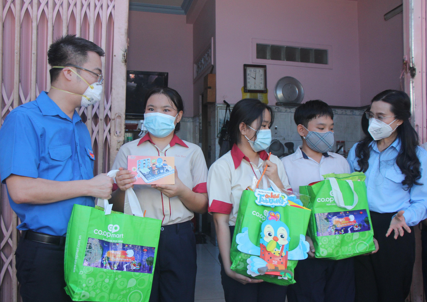 Anh Nguyễn Tường Lâm (bìa trái) và chị Nguyễn Phạm Duy Trang thăm hỏi, tặng quà cho em Tiền Định (thứ hai từ trái qua) và các anh em trong gia đình.