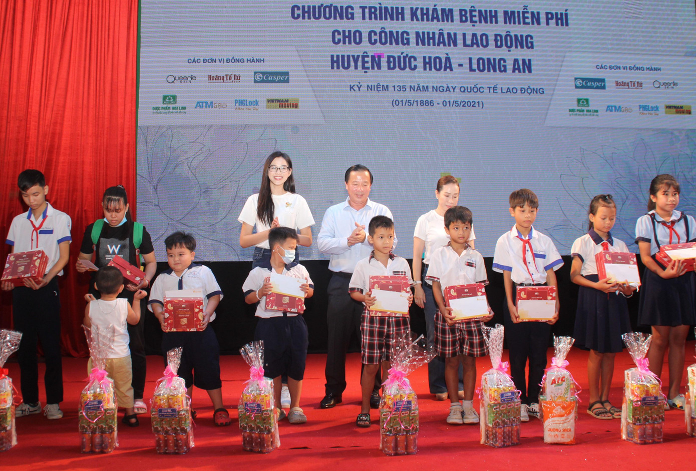 Chủ tịch UBND tỉnh Long An Nguyễn Văn Út (đứng giữa, hàng sau) và Hoa hậu Đỗ Thị Hà trao học bổng cho các em học sinh huyện Đức Hòa