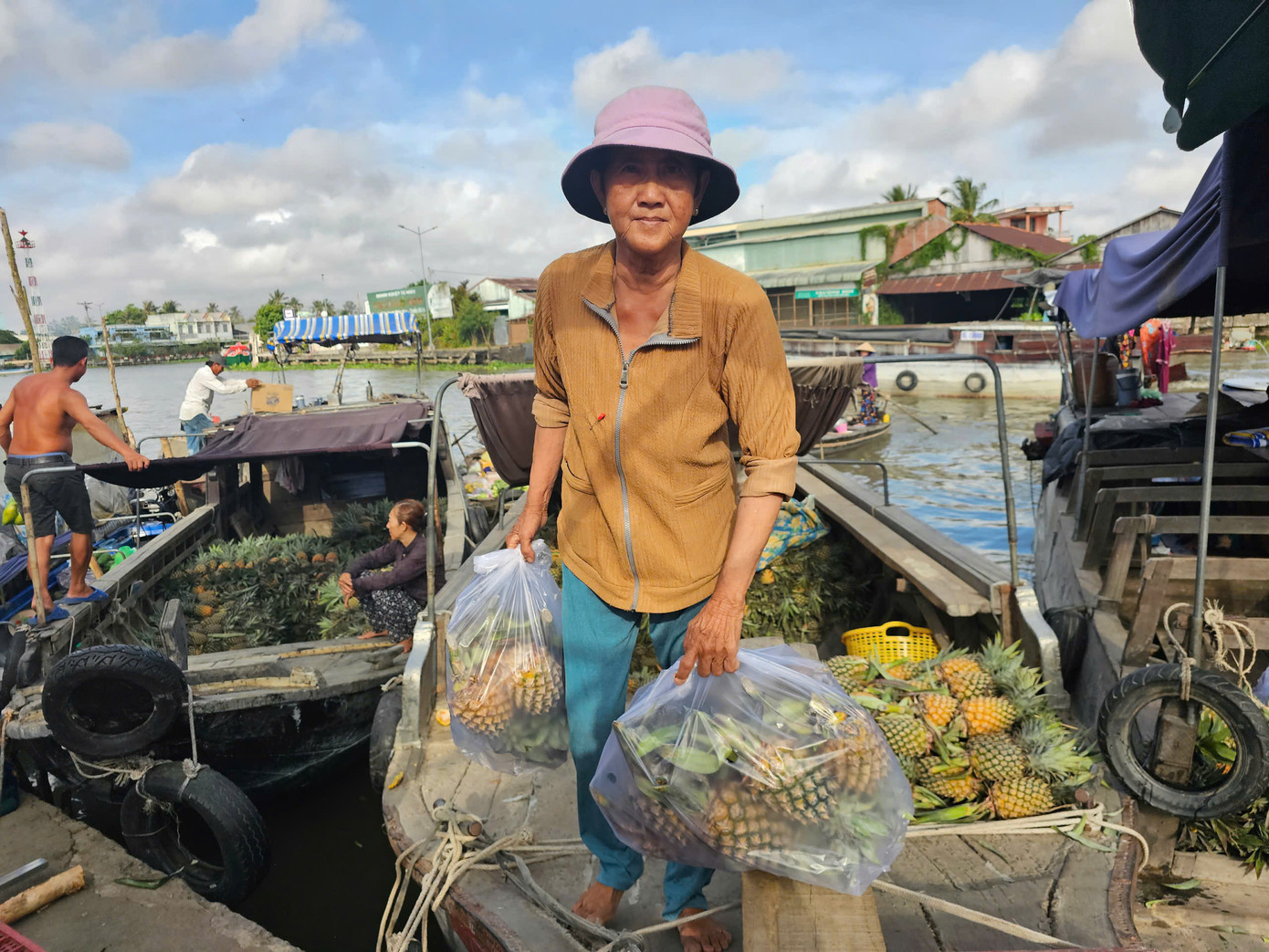 Bà Thái Thị Gấm bán khóm tại chợ nổi Ngã Năm. Ảnh: Hòa Hội