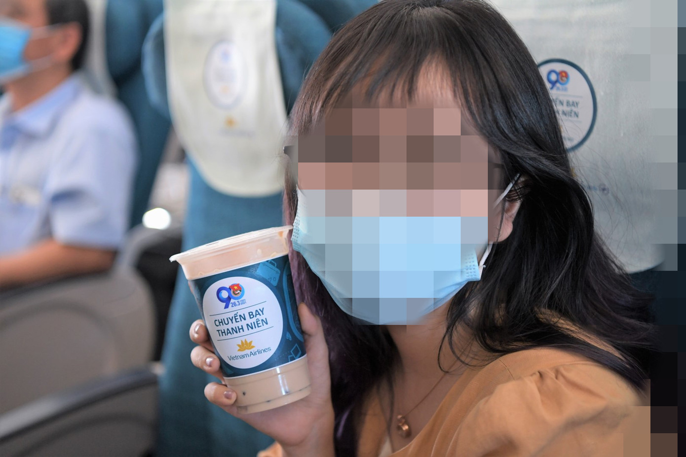 Hành khách trẻ thích thú với sản phẩm trà sữa trên chuyến bay. Ảnh: VNA