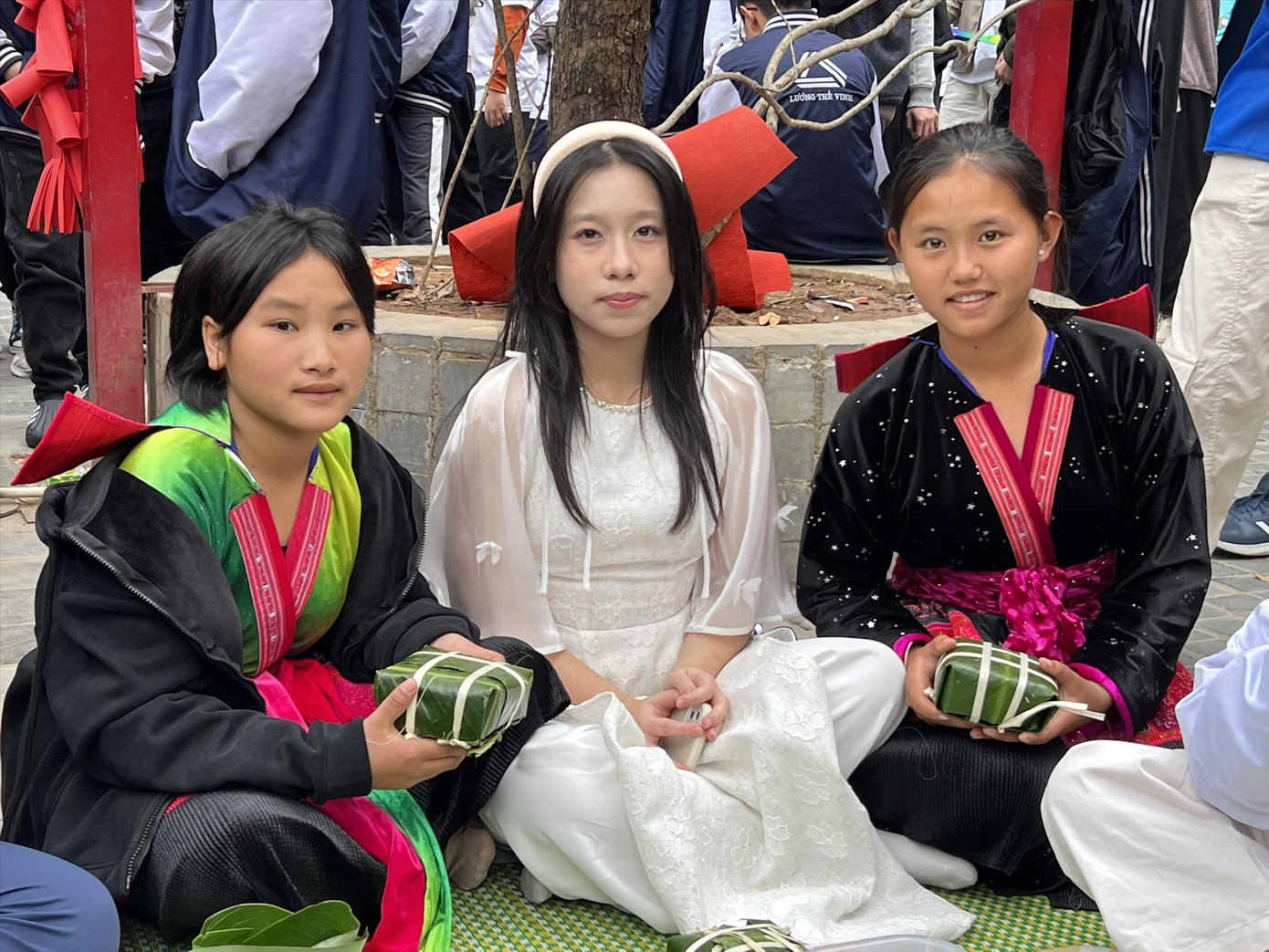 Giàng Thị Hờ (ngoài cùng bên phải) và Giàng Thu Hà (ngoài cùng bên trái) khoe ảnh gói bánh chưng cùng học sinh Hà Nội