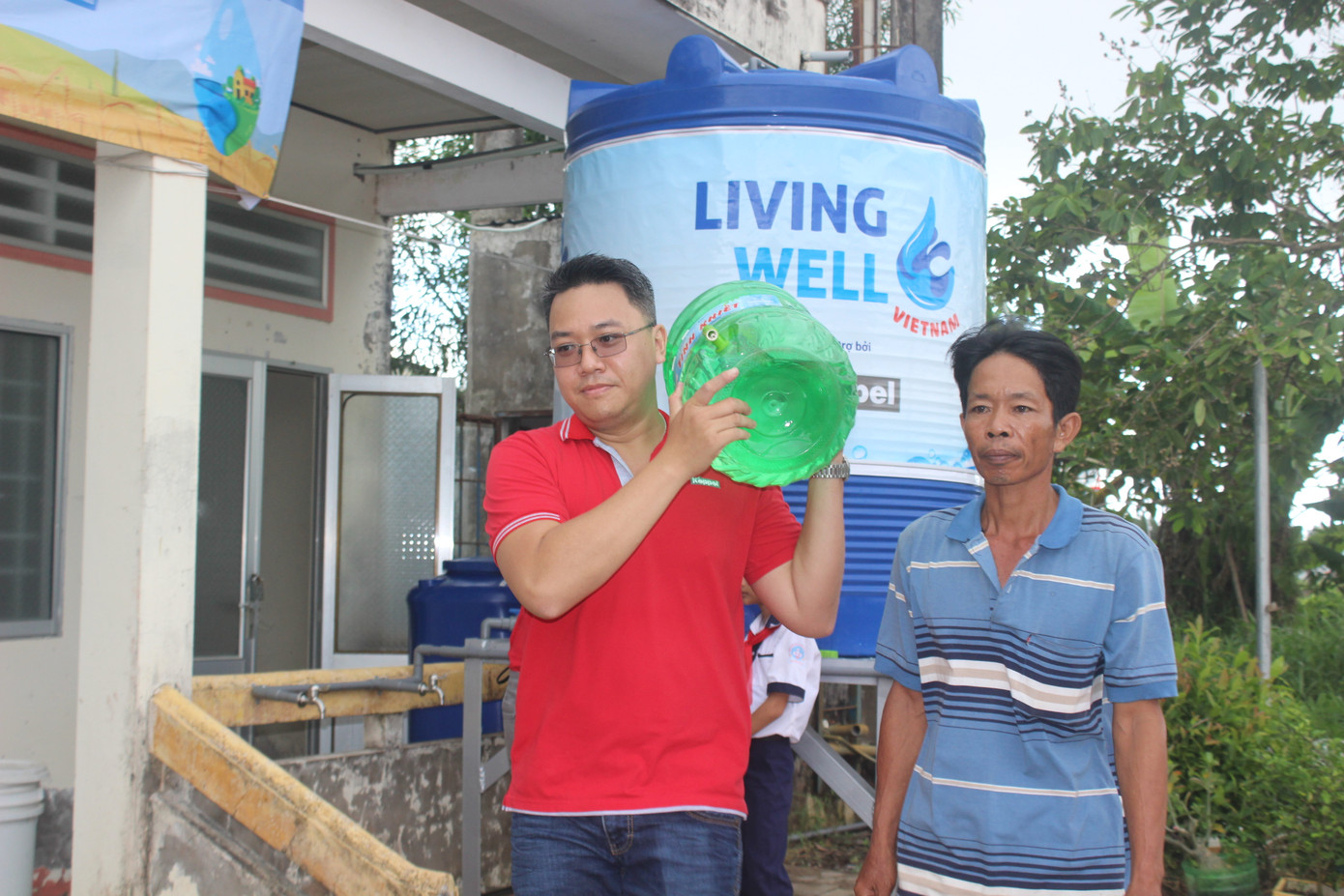 Tình nguyện viên hỗ trợ mang nước cho người dân ra xe trong buổi Lễ khánh thành hệ thống máy lọc nước nhiễm mặn. Tình nguyện viên hỗ trợ mang nước cho người dân ra xe trong buổi Lễ khánh thành hệ thống máy lọc nước nhiễm mặn.