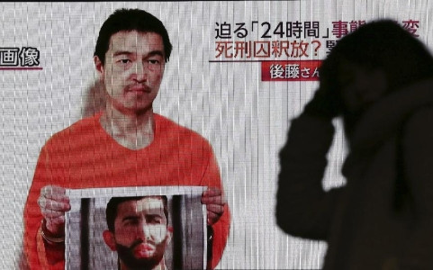 Một người Nhật Bản theo dõi thông tin về con tin Goto (Ảnh Reuters)