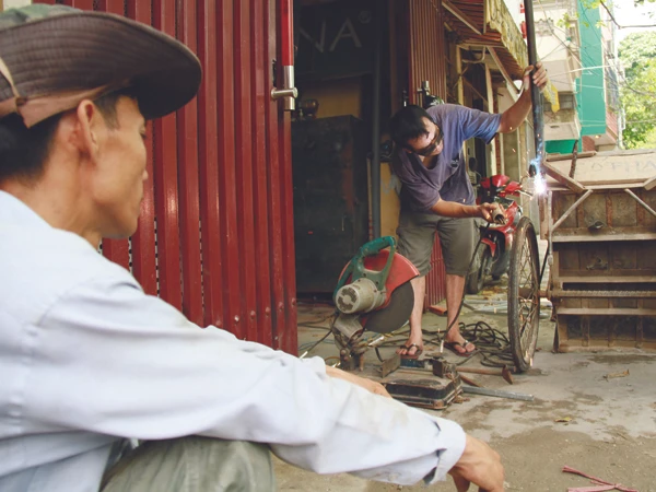 Anh Sinh đi hàn càng chiếc xe Số phận. Ảnh: Trường Phong. Anh Sinh đi hàn càng chiếc xe Số phận. Ảnh: Trường Phong