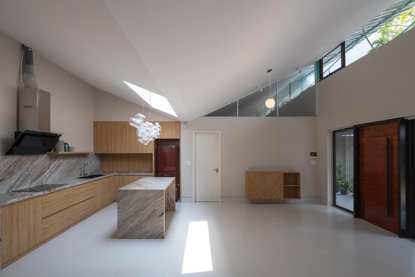 Cạnh phòng khách là nhà bếp, ở đây có một giếng trời, cung cấp ánh sáng cho gian phòng vào ban ngày nhằm tiết kiệm điện năng. Hai bên hông nhà được thiết kế nhỏ hơn để làm không gian riêng tư như phòng ngủ, nhà vệ sinh. Các kiến trúc sư sử dụng kính trong để làm cửa chính và lắp trên các ô thoáng để ánh sáng tràn được vào mọi ngóc ngách trong nhà. Phần mái hình cánh bướm giúp cho ngôi nhà có sự pha trộn giữa truyền thống và hiện đại. Bản vẽ thiết kế của ngôi nhà.