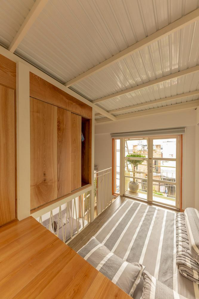 Gia chủ khẳng định hệ thống mái thái kép mang đến cho người trong nhà sự thoải mái tuyệt vời trong những ngày hè tại TP.Hồ Chí Minh. Vì nằm trên diện tích đất dài và hẹp nên căn nhà lùi sâu vào trong, khoảng đất phía mặt đường được thiết kế làm sân và nơi bán nước. Ở tầng trệt, cửa trước được thiết kế rộng để người mua nước có thể vào ngồi nếu như ngoài sân không còn chỗ. Phía sau phòng khách còn có một phòng ngủ nhỏ dành cho khách đến chơi nhà và ngủ lại qua đêm. Cầu thang nhà vòng qua một cây khế được trồng bên dưới giếng trời để ngôi nhà vừa có ánh nắng vừa có sự xanh mát của cây cối. Phòng ngủ chính ở tầng 1 có cửa sổ lớn, góc đọc sách nhìn ra giếng trời cũng như phòng học của con trai. Để tối đa hóa không gian sống và tạo nơi giải trí cho cậu con trai nhỏ, gia chủ thiết kế phòng ngủ, phòng học và phòng chơi của cậu bé ở các vị trí lệch tầng. Điều này dẫn đến hai ban công của hai tầng nhà nằm lệch nhau và cùng nhìn ra phía sân trước. Ngôi nhà sử dụng sơn ngoại thất màu trắng kết hợp với màu vàng của cầu thang và màu xanh tự nhiên của cây cối. Toàn cảnh ngôi nhà. Bản vẽ sơ bộ của ngôi nhà. Bản vẽ thiết kế của phần mái Bản vẽ thiết kế của tầng 1 (1: Nơi bán cà phê; 2: Phòng bếp; 3: Phòng ngủ: 4: Phòng vui chơi).