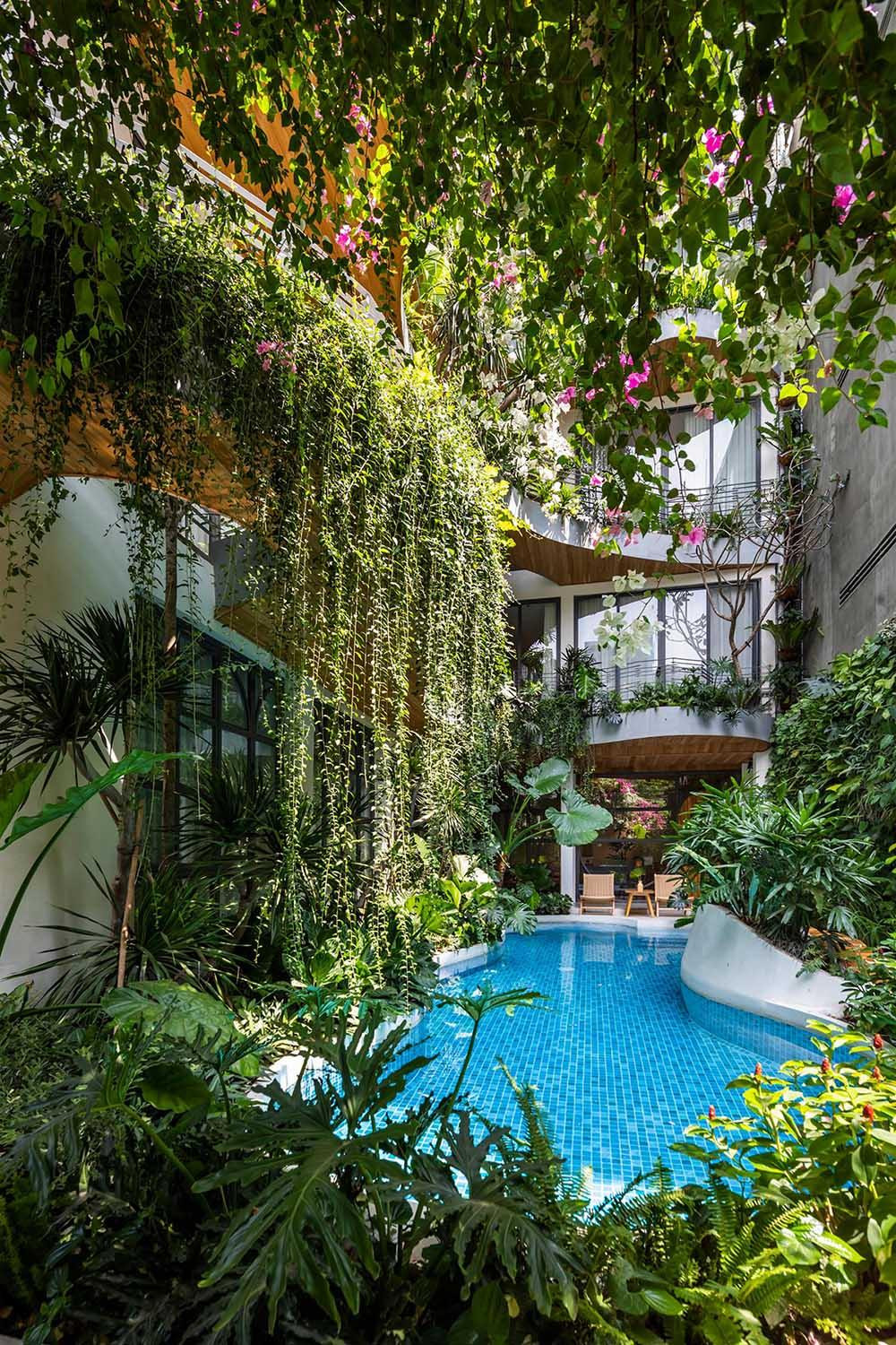 Những cây dây leo tươi tốt đổ xuống từ các ban công nhấp nhô của tòa nhà, tạo nên một mặt tiền xanh mát mang lại không khí trong lành và thư giãn.