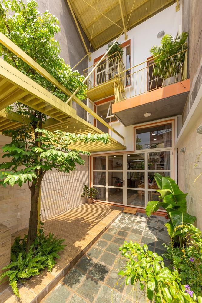 Vì nằm trên diện tích đất dài và hẹp nên căn nhà lùi sâu vào trong, khoảng đất phía mặt đường được thiết kế làm sân và nơi bán nước.