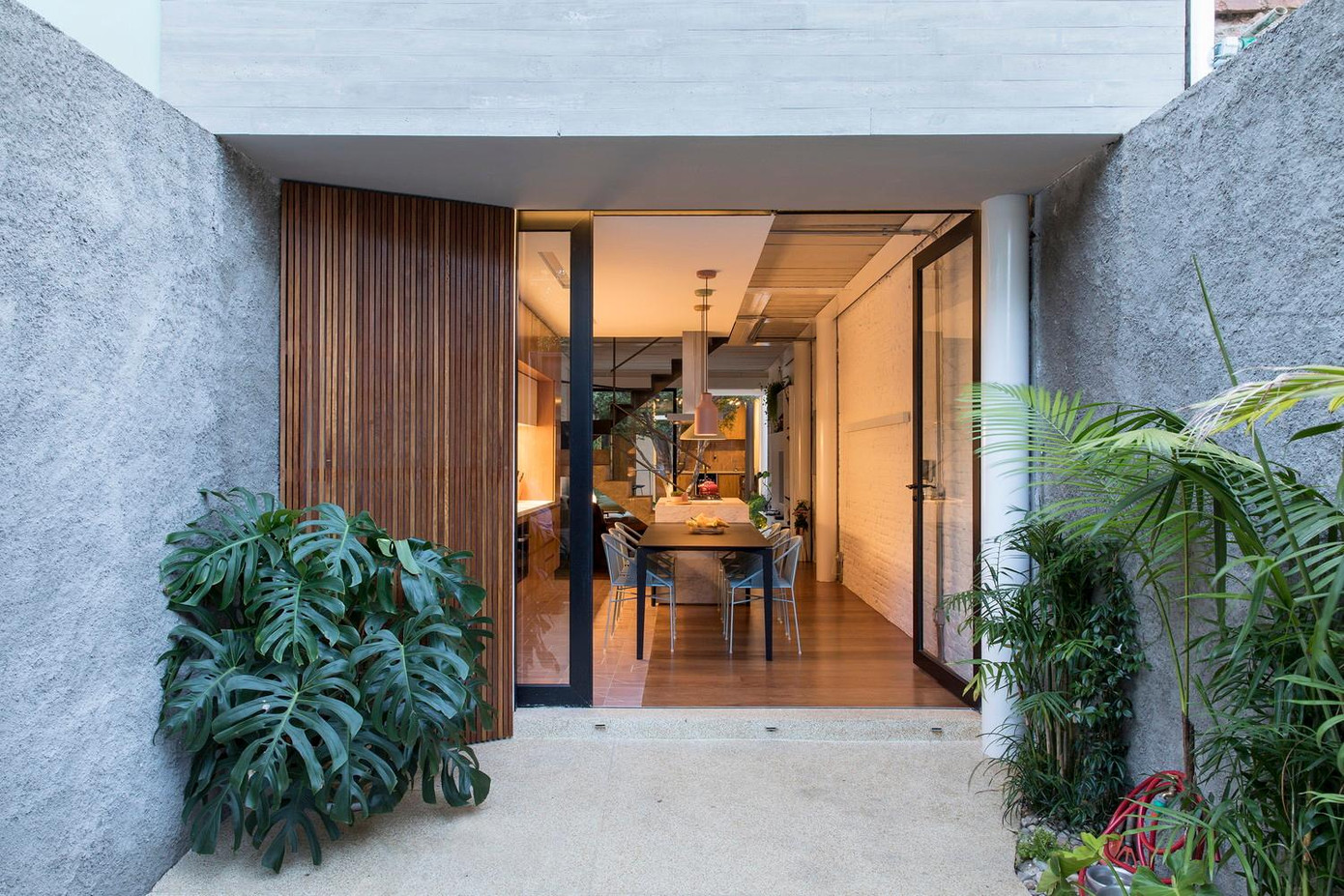 Tầng trệt bao gồm nhà bếp, phòng khách nhìn thẳng ra khu vườn phía mặt đường lớn thông qua cánh cửa kính trượt để mở rộng không gian.