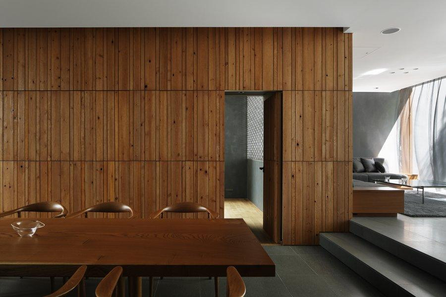 Ánh sáng được lọc qua những tán cây trong vườn le lói trên sàn phòng khách và một tấm rèm siêu nhẹ bằng kim loại phủ bóng bay múa trong gió.