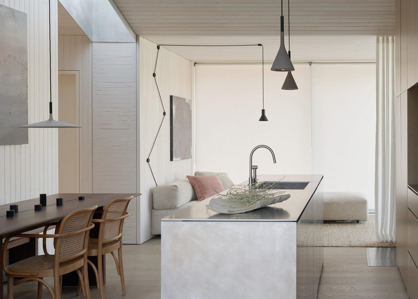 Ngôi nhà dùng cửa trượt để tiết kiệm không gian. Bên trong nhà được chia thành hai khu. Một bên bao gồm các không gian chung - nhà bếp mở và khu vực ăn uống, được ngăn cách với phòng khách bằng rèm vải có thể thu vào.