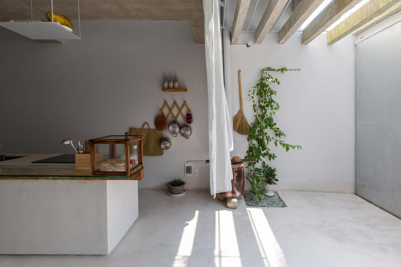 Với điều kiện thời tiết của miền Nam Việt Nam không có mùa đông nên các kiến trúc sư phải bố trí các khe thông gió cố định trên bề mặt của ngôi nhà (mặt tiền, mặt sau, tầng thượng). Bởi về cơ bản, ngoài cửa chính (tầng 1) ngôi nhà này hầu như không có cửa sổ, nên việc thông gió từ trong ra ngoài nhà được thực hiện thông qua các khe cố định này. Điều này giúp giảm chi phí cho phần cửa cũng như giảm thời gian đóng cửa sổ cho những gia chủ độc thân. Tuy nhiên, việc xử lý chống nóng cho ngôi nhà hướng Tây chính là một thách thức lớn. Do đó, bên ngoài nhà, nhóm thiết kế sử dụng bóng cây phía trên (cây cao phía trước, cây leo phía sau) làm mái hiên lớn. Bên trong, họ sử dụng không gian đệm, rèm vải, rèm tre có tác dụng điều chỉnh phần ánh sáng trực tiếp từ bên ngoài. Các kiến trúc sư chia công năng của ngôi nhà thành 2: Phần không gian động bao gồm bếp, phòng ăn, phòng khách; không gian tĩnh gồm 2 phòng ngủ, 1 dành cho chủ nhà, 1 dành cho khách. Đối với không gian tĩnh, nhóm thiết kế tận dụng vị trí chính Đông Tây của khu đất để làm phòng ngủ ở phía Đông, nơi có ánh sáng dịu vào buổi sáng (phía sau). Giường ngủ được kết cấu như một chiếc giường tầng với phần dưới dành cho chủ nhà, phần trên là cho khách. Các không gian khác đặt ở phía Tây, nơi có ánh hoàng hôn vào buổi chiều. Trong đó bếp và bàn ăn là trung tâm (tầng 1). Các không gian này gần như thông thoáng tuyệt đối và nhìn ra được con đường yên tĩnh trước nhà để người độc thân như chủ nhà có thể nhìn thấy những hàng xóm xung quanh. Bản vẽ của ngôi nhà.