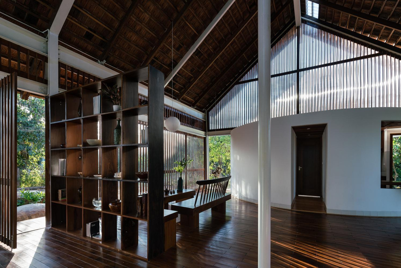 Đồng thời, nhờ sử dụng những tấm cửa kính dạng song gỗ, không gian ngôi nhà trở nên đa chiều hơn, một mặt kết nối hai khối chức năng chính, mặt khác kết nối không gian bên ngoài và bên trong.