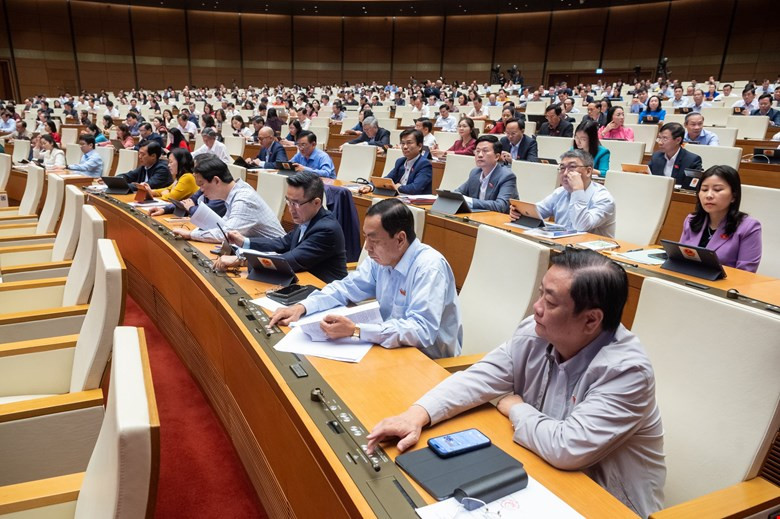 Các đại biểu Quốc hội biểu quyết thông qua Luật Nhà ở (sửa đổi).