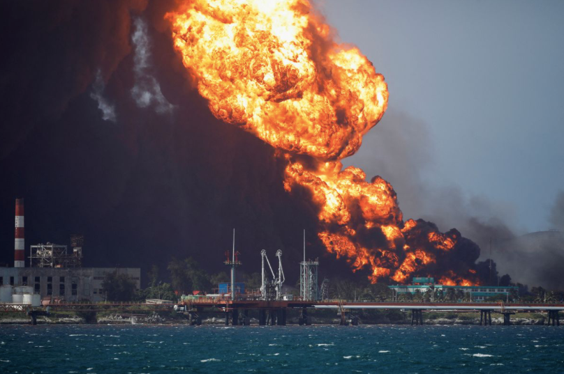 Lửa và đám khói đen khổng lồ bốc lên từ kho dầu Matanzas khi đám cháy chưa được dập tắt. (Ảnh: Reuters)