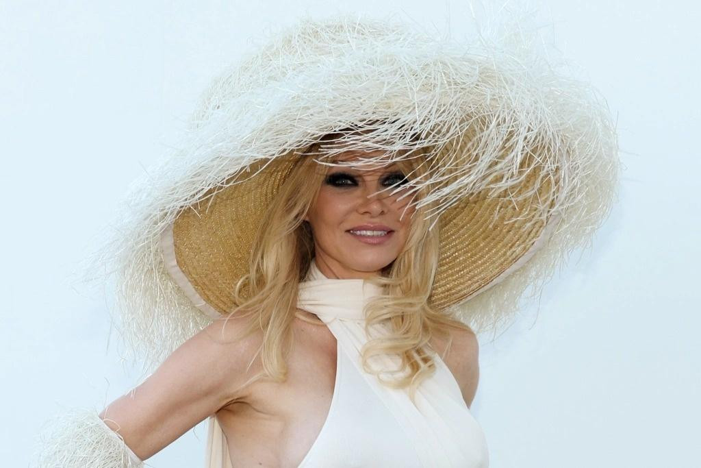 Pamela Anderson là một trong những nghệ sĩ nổi tiếng góp mặt trong show diễn. Cô mặc bộ váy theo phong cách cổ điển, phối hợp găng tay tua rua và mũ rộng vành.