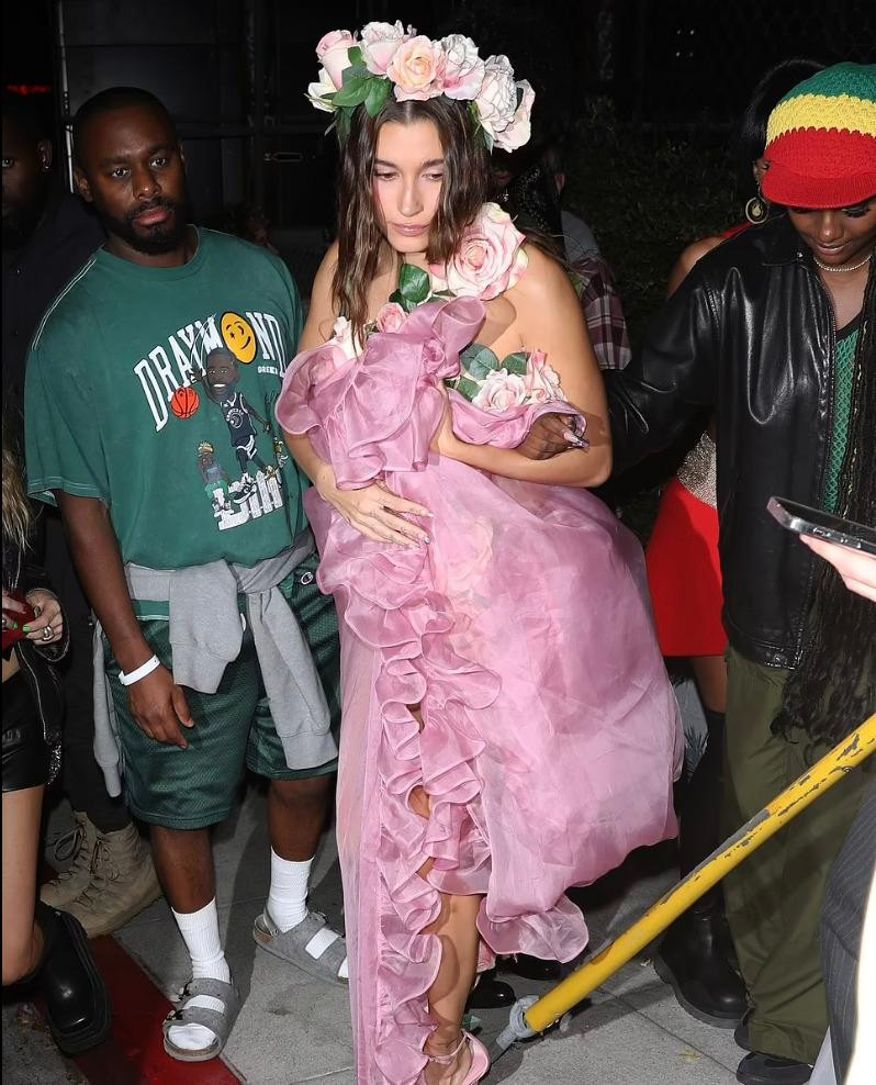 Năm nay, Hailey Bieber có màn hóa thân nữ tính. Hailey đã mặc trang phục đính hoa hồng giống bộ đồ của Laetitia Casta trong buổi trình diễn thời trang Yves Saint Laurent SS99 vào năm 1999.