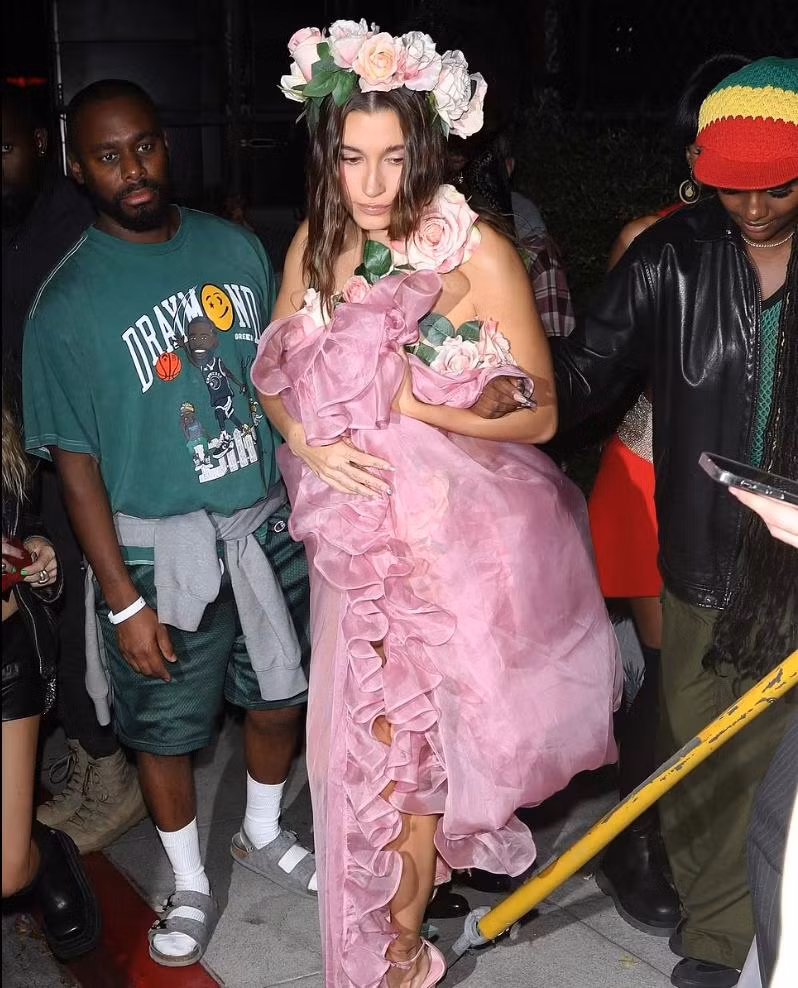 Năm nay, Hailey Bieber có màn hóa thân nữ tính. Hailey đã mặc trang phục đính hoa hồng giống bộ đồ của Laetitia Casta trong buổi trình diễn thời trang Yves Saint Laurent SS99 vào năm 1999.