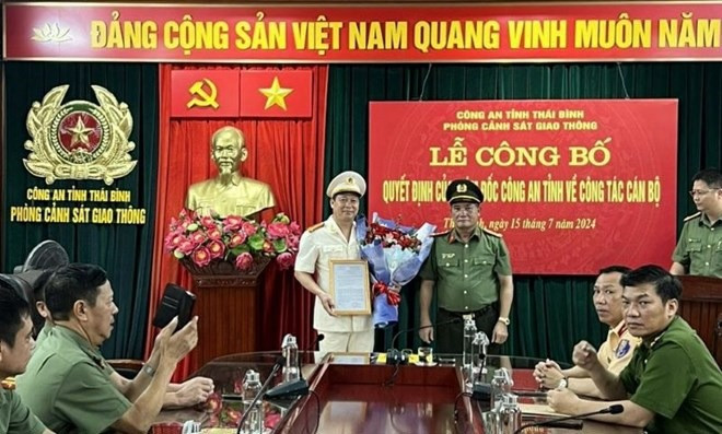 Đại tá Phạm Đình Tâm - Phó Giám đốc Công an tỉnh Thái Bình trao quyết định, tặng hoa chúc mừng Trung tá Nguyễn Hòa Hiệp. Ảnh: Công an tỉnh Thái Bình.