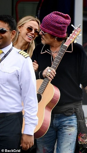 Vlasova khoác tay Depp và cười nói khi hai người ra khỏi sân bay trực thăng London vào ngày 11/7. Ảnh: BackGrid. Vlasova khoác tay Depp và cười nói khi hai người ra khỏi sân bay trực thăng London vào ngày 11/7. Ảnh: BackGrid.