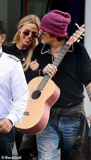 Vlasova khoác tay Depp và cười nói khi hai người ra khỏi sân bay trực thăng London vào ngày 11/7. Ảnh: BackGrid. Vlasova khoác tay Depp và cười nói khi hai người ra khỏi sân bay trực thăng London vào ngày 11/7. Ảnh: BackGrid.