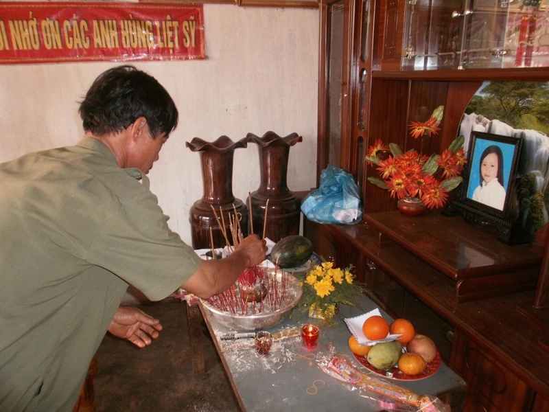 Ông Nguyễn Sỹ Diệu đang thắp hương cho con gái. Ông Nguyễn Sỹ Diệu đang thắp hương cho con gái