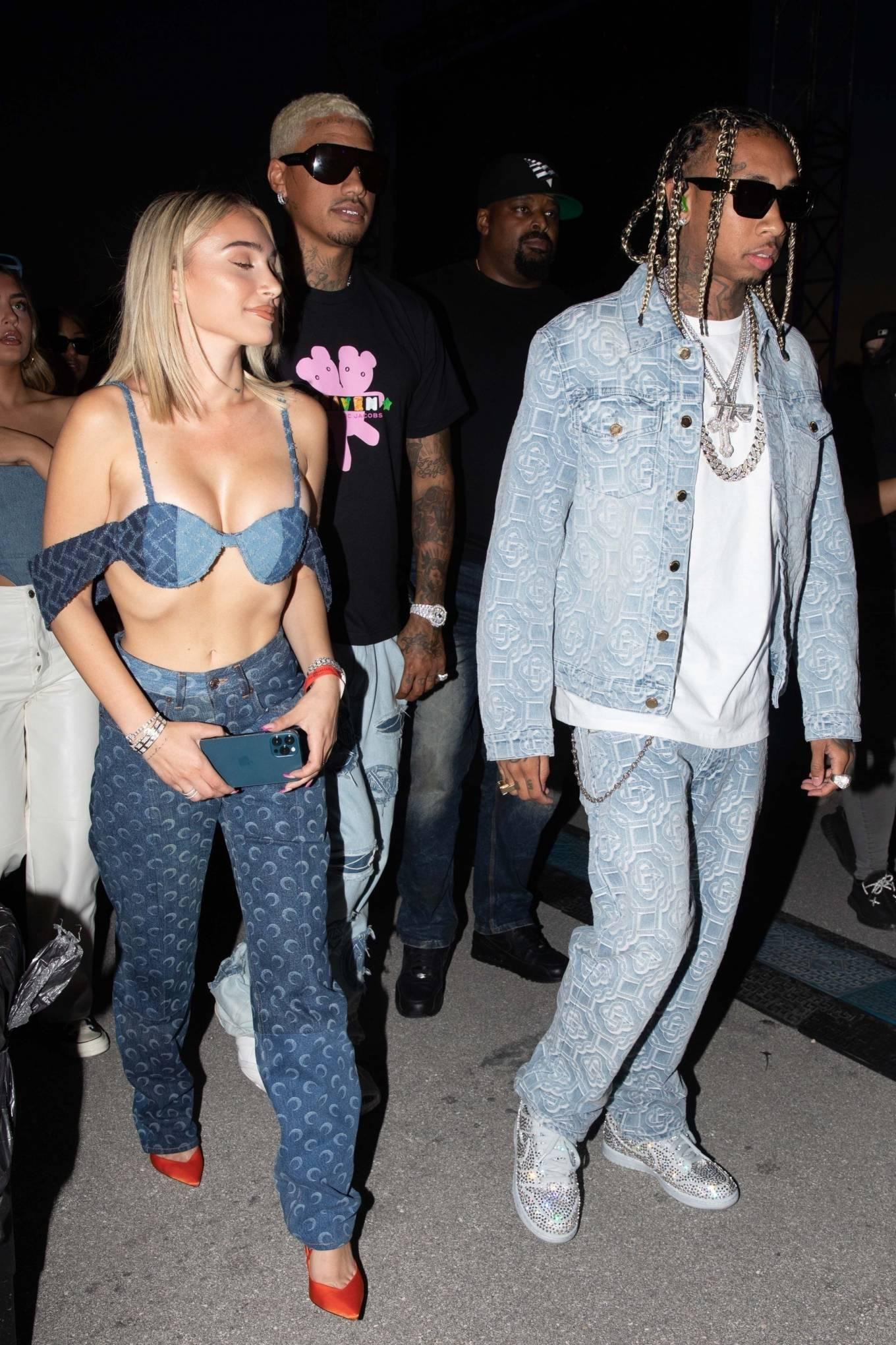 Cặp đôi mới đây được trông thấy mặc đồng điệu ra phố ở Miami (Mỹ). Trong khi Tyga (SN 1989) mặc kín đáo thì bạn gái kém 10 tuổi mặc áo lót buông lơi ra phố khiến người nhìn không khỏi nóng mắt.