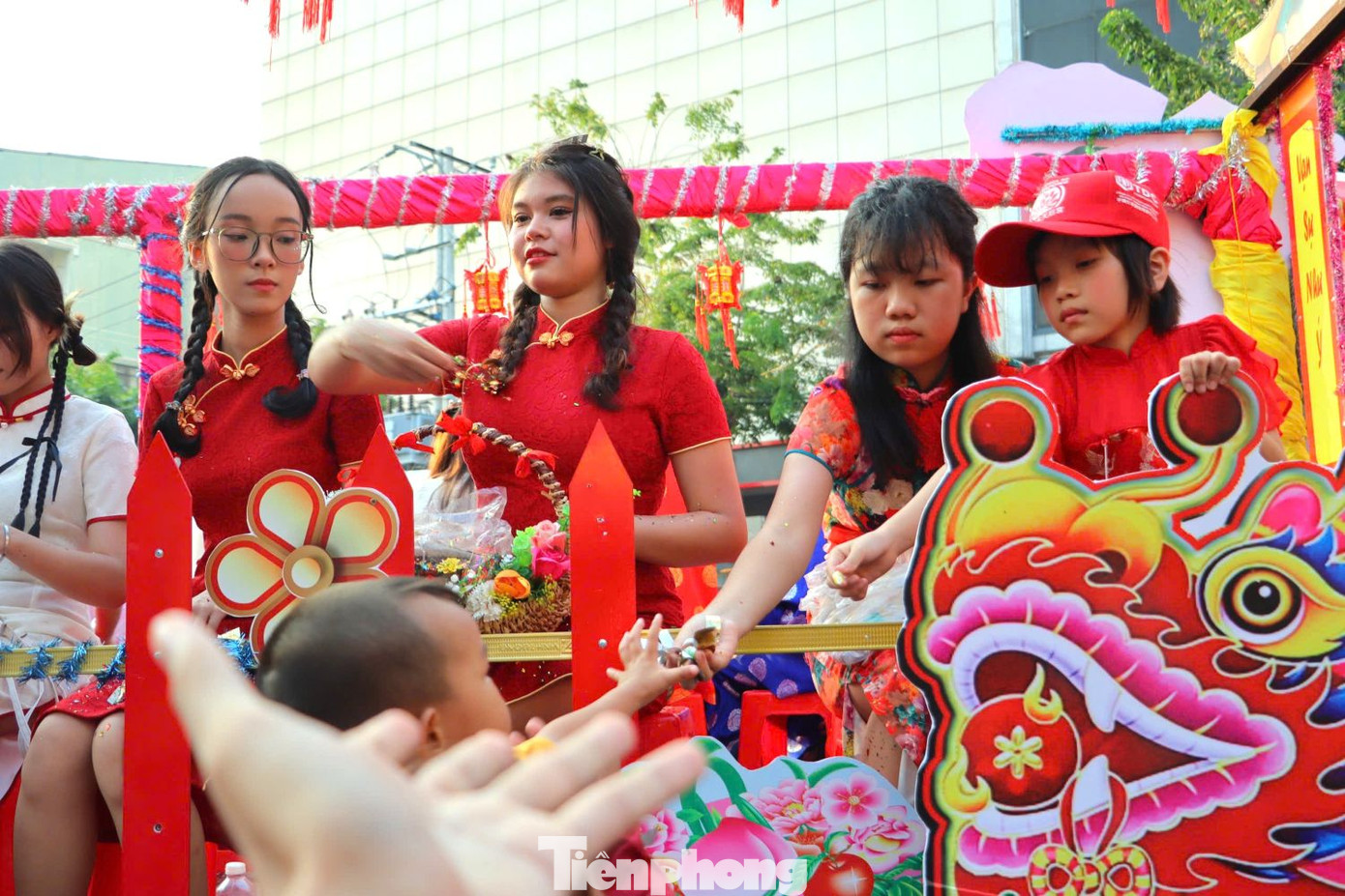 Các cô gái trẻ ngồi trên xe liên tục rải hoa xuống đường ban phước.