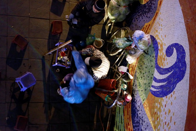 Người bán trà đá vỉa hè vào ban đêm trong gió lạnh tại đường Âu Cơ với giá 2.000 đồng/chén trà nóng 