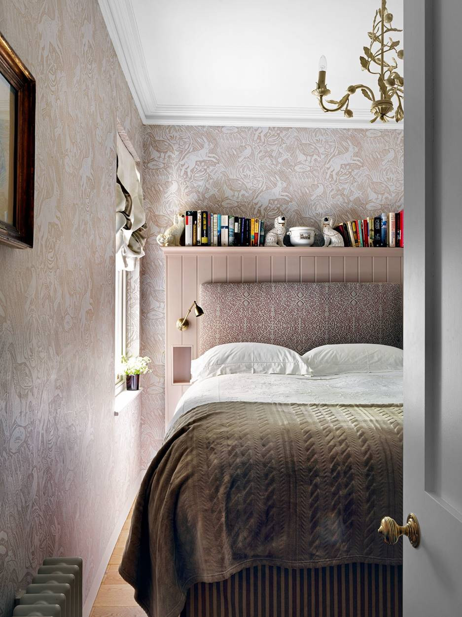 Tấm ốp tường sau giường đảm nhiệm nhiều vai trò: tích hợp đèn ngủ, tạo các hốc làm bàn đầu giường và thêm một kệ phía trên vừa trang trí vừa tiện dụng.