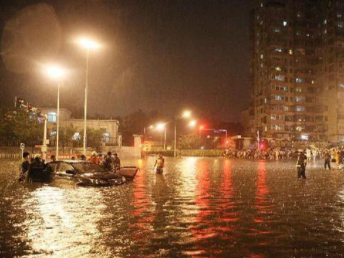 Các nhân viên cứu hộ đang kéo một chiếc xe ngập trong nước ở Bắc Kinh