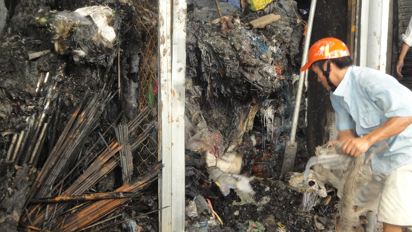 Một tiểu thương chợ Vinh đang cố vớt vát những gì còn sót lại sau đám cháy