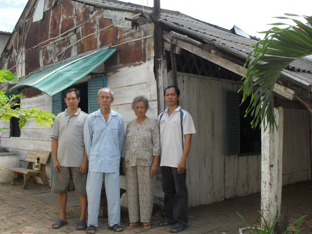 Vợ chồng bà Hương cùng con bên ngôi nhà sinh sống hơn 30 năm, từ khi bị thu hồi đất. Ảnh: Tuấn Anh.