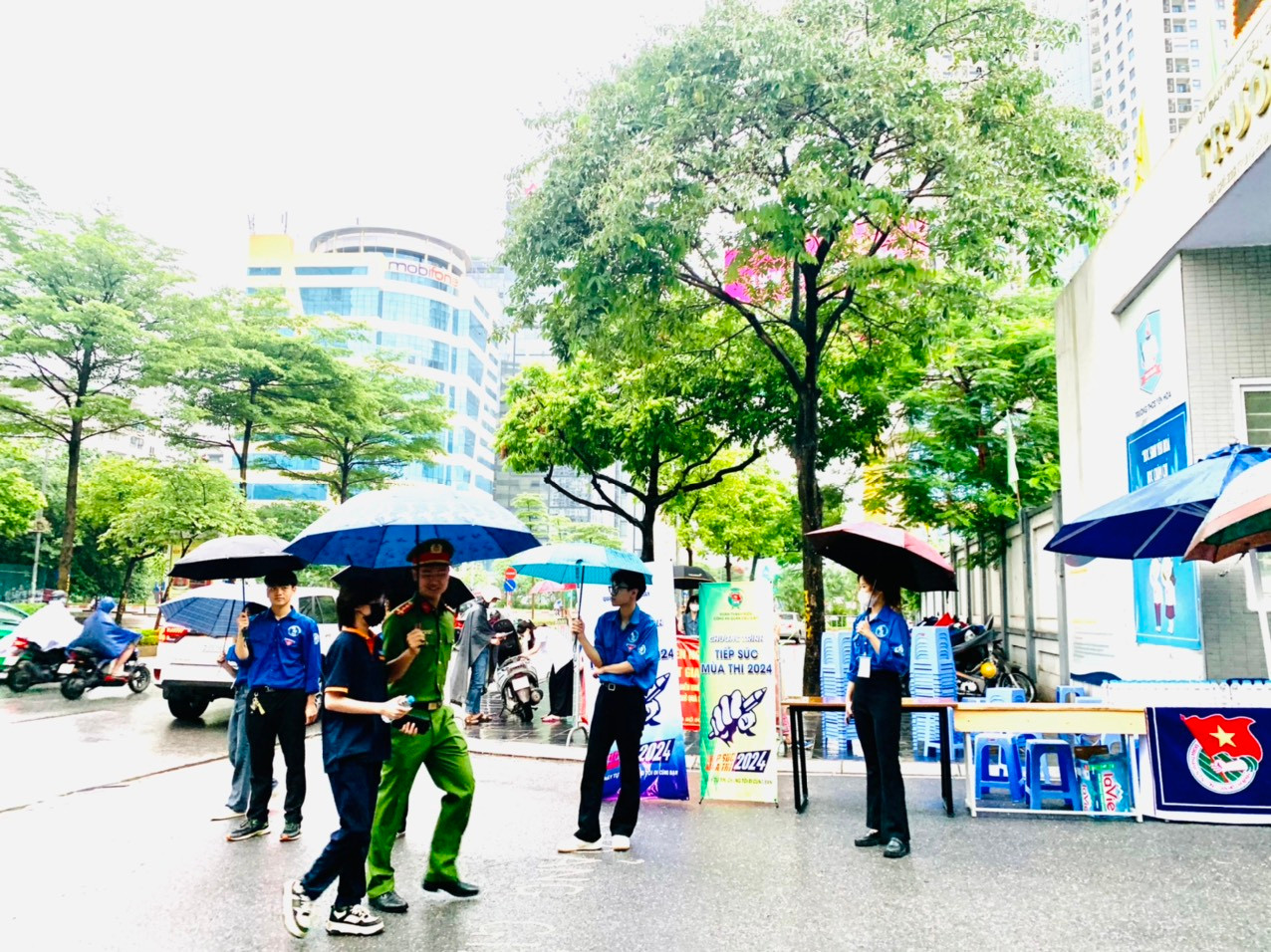 Là chú công an che mưa cho thí sinh. Ảnh: Đỗ Hợp