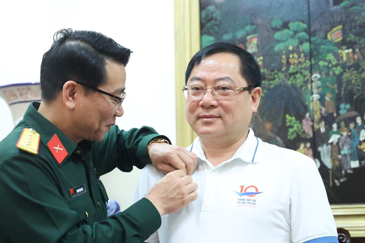 Đại tá Phạm Văn Hiếu trao Huy hiệu Bác Hồ cho nhà báo Lê Xuân Sơn - Tổng Biên tập Báo Tiền Phong, Giám đốc Quỹ Hỗ trợ Tài năng trẻ Việt Nam; nhà báo Phùng Công Sưởng – Phó Tổng Biên tập báo Tiền Phong, Phó Giám đốc Quỹ Hỗ trợ Tài năng trẻ Việt Nam