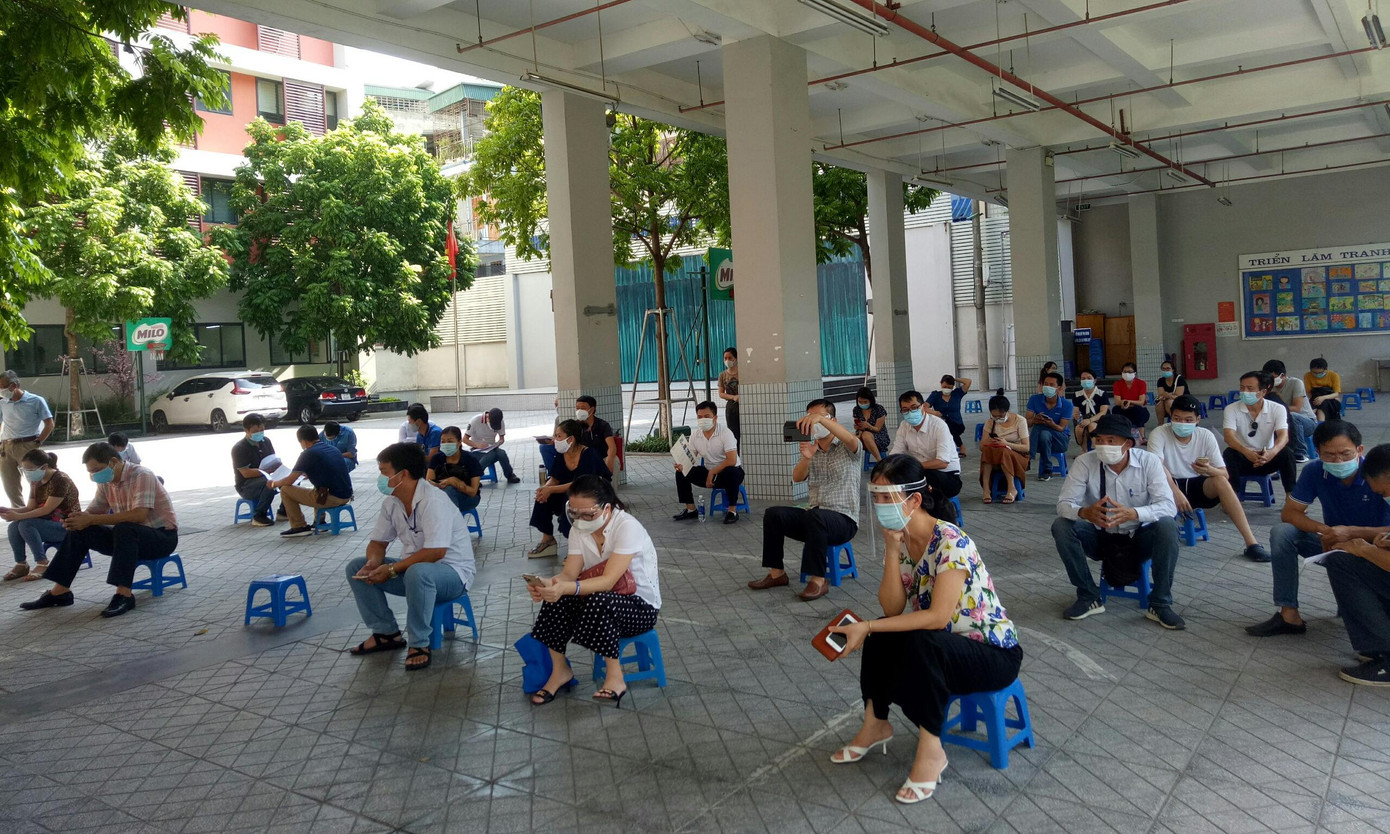 Người dân giữ khoảng cách đến làm thủ tục tiêm chủng.