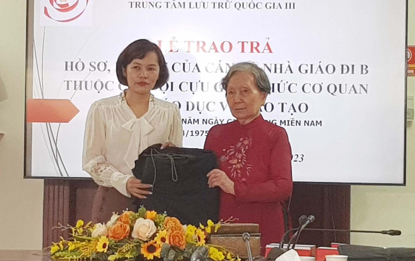 Cựu cán bộ đi B Nguyễn Thị Hân (phải) tặng chiếc võng kỷ vật của chồng (cũng là một cán bộ đi B) cho Trung tâm Lưu trữ Quốc gia III. Ảnh: Kiến Nghĩa.