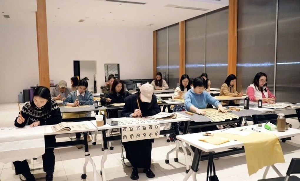 Nhiều người trẻ tham gia lớp học thư pháp tại một trường học ban đêm ở Trung Quốc (Ảnh: Weibo).