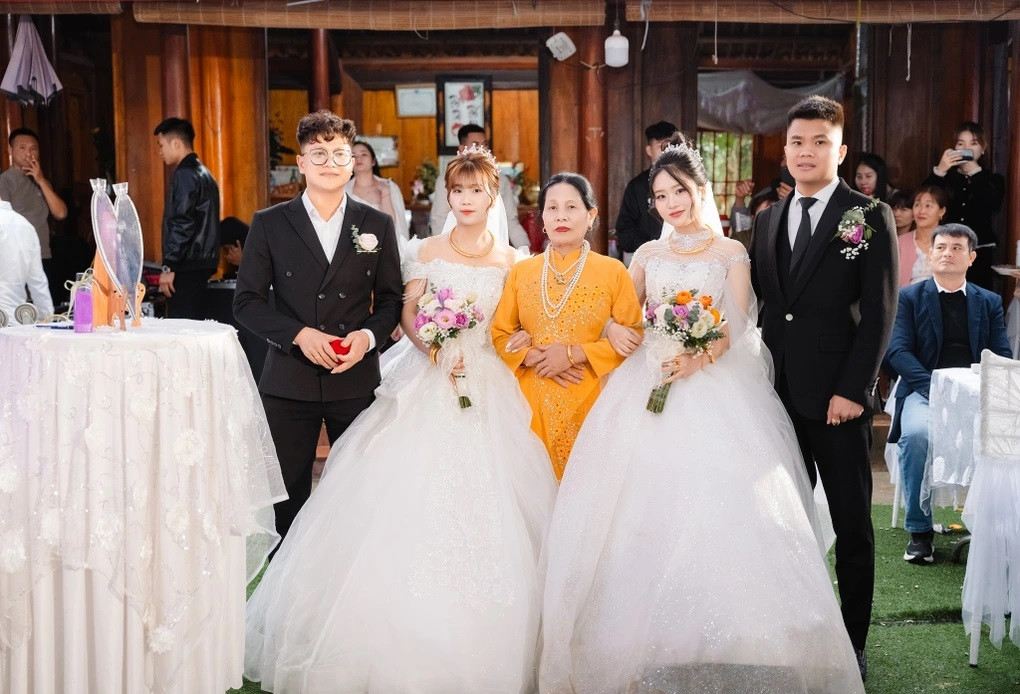 Người mẹ đỡ tay hai cô dâu tiến vào lễ đường. Trong ảnh, anh Thụ - chị Hường (bên trái) và anh Hậu - chị Thảo (bên phải) (Ảnh: Nhân vật cung cấp). Người mẹ đỡ tay hai cô dâu tiến vào lễ đường. Trong ảnh, anh Thụ - chị Hường (bên trái) và anh Hậu - chị Thảo (bên phải) (Ảnh: Nhân vật cung cấp).