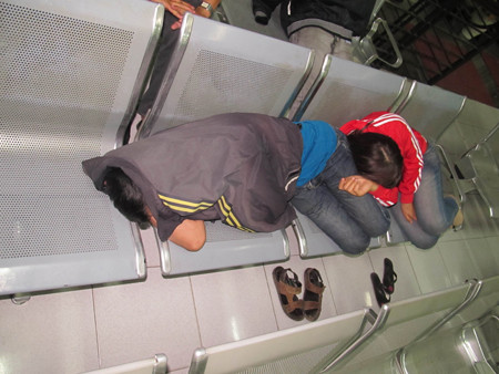 Một số hành khách đến sớm ngủ tại nhà ga chờ lấy số thứ tự