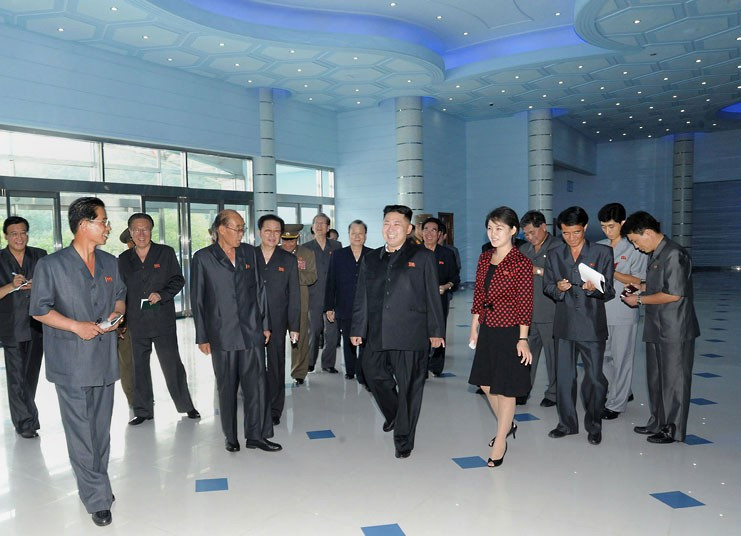Vợ chồng ông Kim Jong Un trao đổi cùng các quan chức khác 
