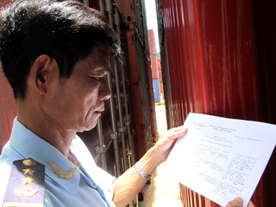 Một cán bộ Hải quan cầm danh sách 21 xe còn nằm trong container ở cảng Tiên Sa