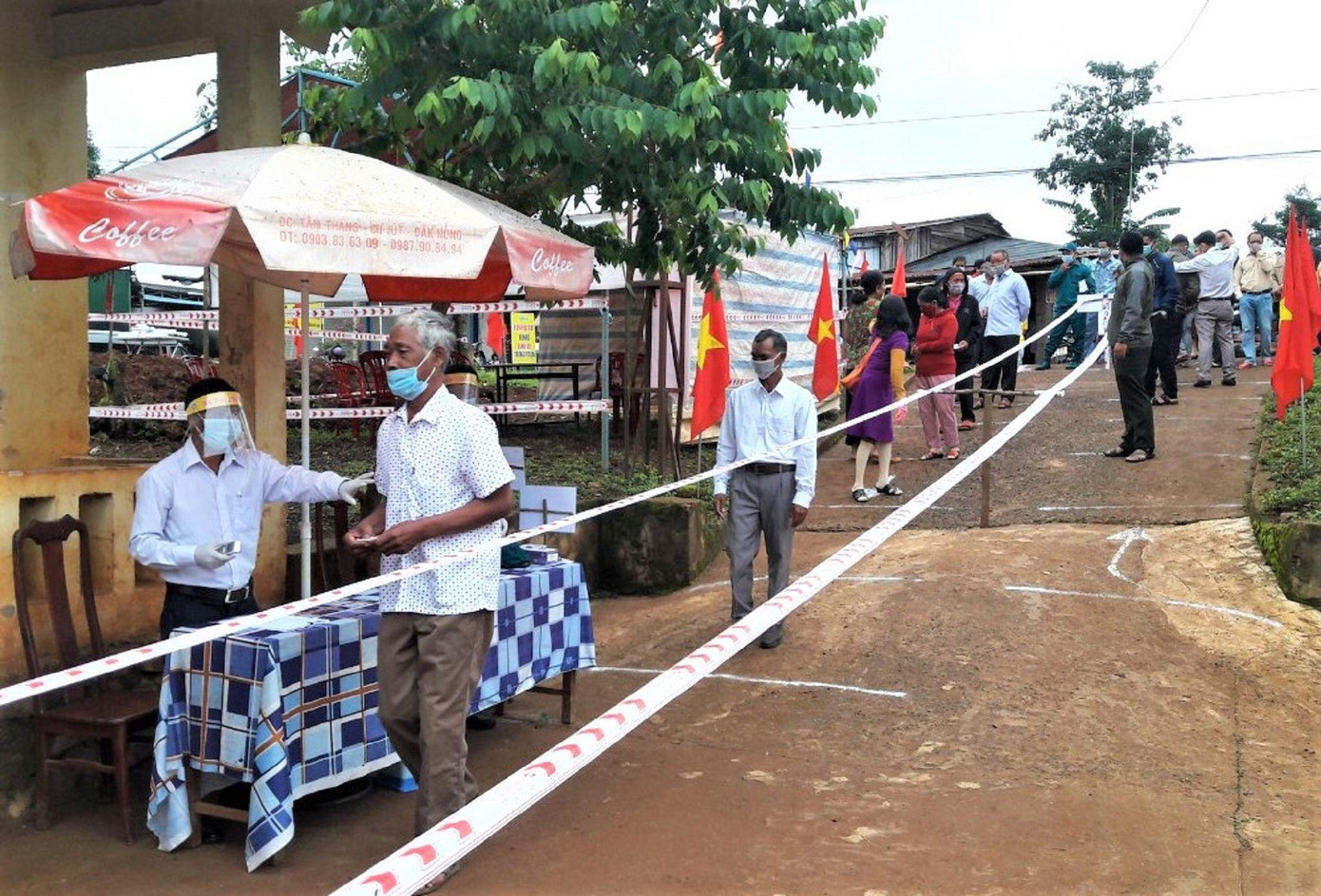 Lực lượng chức năng thực hiện kiểm tra thân nhiệt cử tri Đắk Som (Đắk G'long, Đắk Nông) trước khi vào khu vực bỏ phiếu Lực lượng chức năng thực hiện kiểm tra thân nhiệt cử tri Đắk Som (Đắk G'long, Đắk Nông) trước khi vào khu vực bỏ phiếu