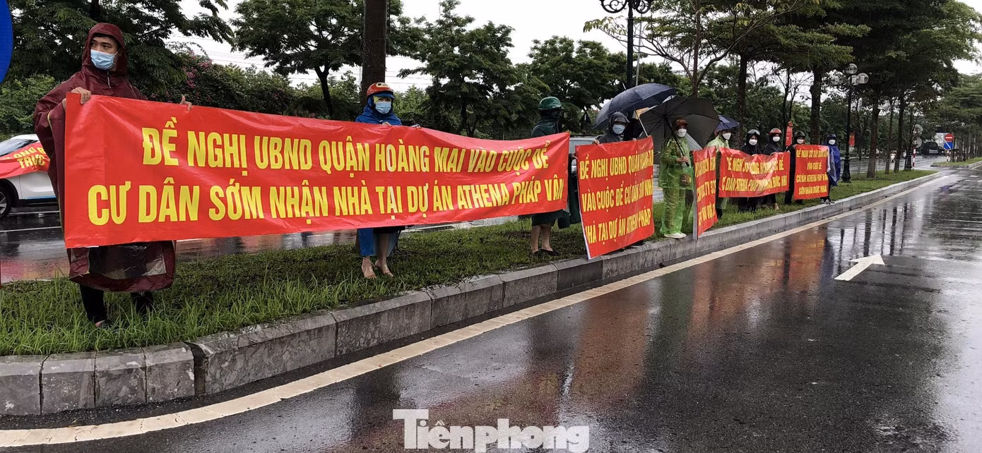 Khách hàng mua căn hộ dự án Athena Complex Pháp Vân (phường Hoàng Liệt, quận Hoàng Mai, Hà Nội) đội mưa, tập trung trước cổng dự án và trụ sở UBND quận Hoàng Mai căng băng rôn đòi nhà, kêu cứu sau nhiều lần chủ đầu tư thất hứa, không bàn giao nhà như cam kết. Khách hàng mua căn hộ dự án Athena Complex Pháp Vân (phường Hoàng Liệt, quận Hoàng Mai, Hà Nội) đội mưa, tập trung trước cổng dự án và trụ sở UBND quận Hoàng Mai căng băng rôn đòi nhà, kêu cứu sau nhiều lần chủ đầu tư thất hứa, không bàn giao nhà như cam kết.