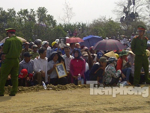 Người dân mang di ảnh Đại tướng đội nắng chờ ở Vũng Chùa. Ảnh: Trần Tuấn