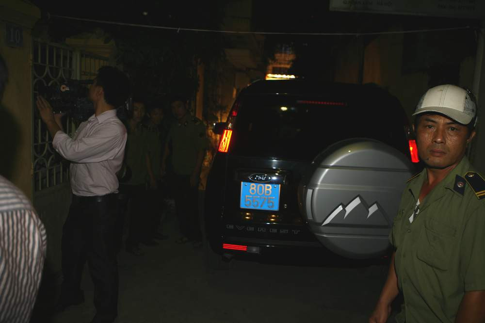 Chiếc xe của cơ quan điều tra rời khỏi nhà ông Bình sau khi thực hiện lệnh khám xét.