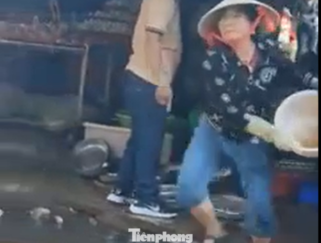 Hình ảnh nữ tiểu thương dội nước vào các thành viên Ban quản lý chợ