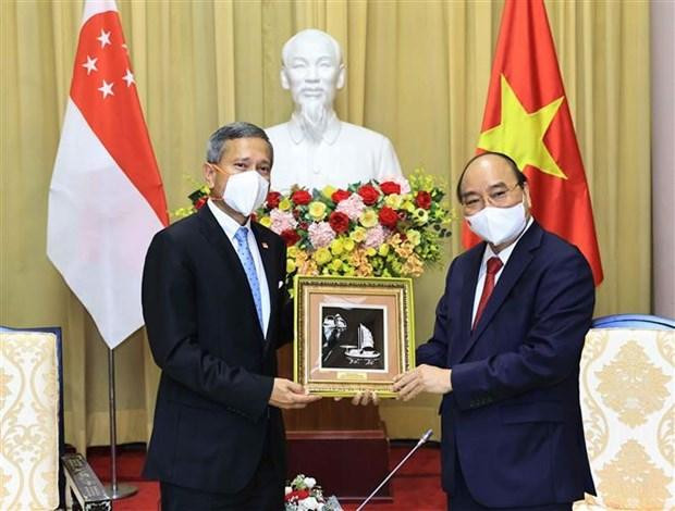Chủ tịch nước Nguyễn Xuân Phúc trao đổi quà lưu niệm với Bộ trưởng Bộ Ngoại giao Cộng hòa Singapore Vivian Balakrishnan tại Phủ Chủ tịch, chiều 21/6/2021. (Ảnh: Thống Nhất/TTXVN)